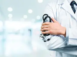 Medico con lo stetoscopio in uno studio luminoso