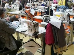 Lavoratori alle macchine da cucire in un laboratorio tessile