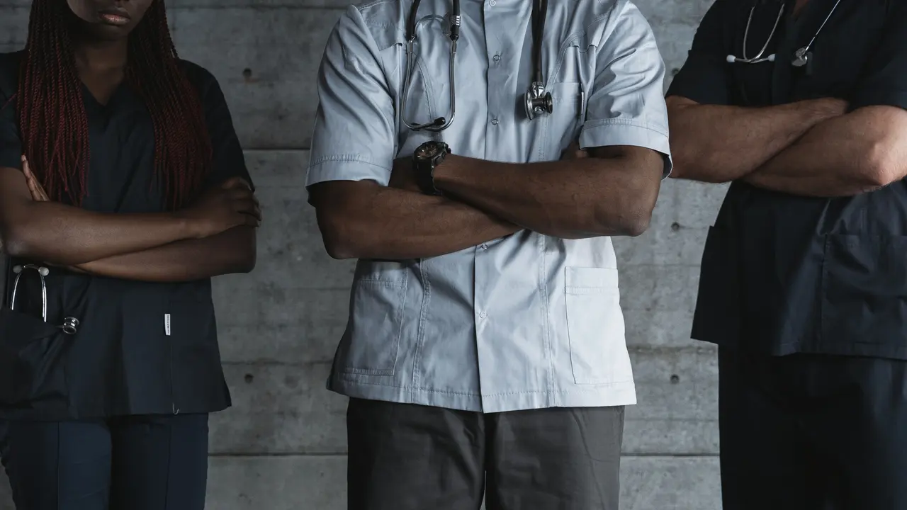 Tre professionisti sanitari con lo stetoscopio e le braccia incrociate