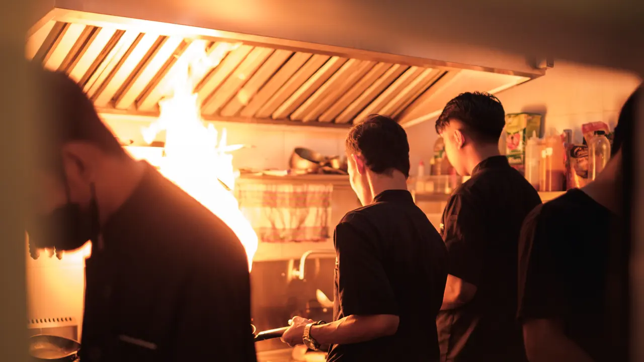 Cucina di un ristorante: i cuochi al lavoro davanti alla fiamma